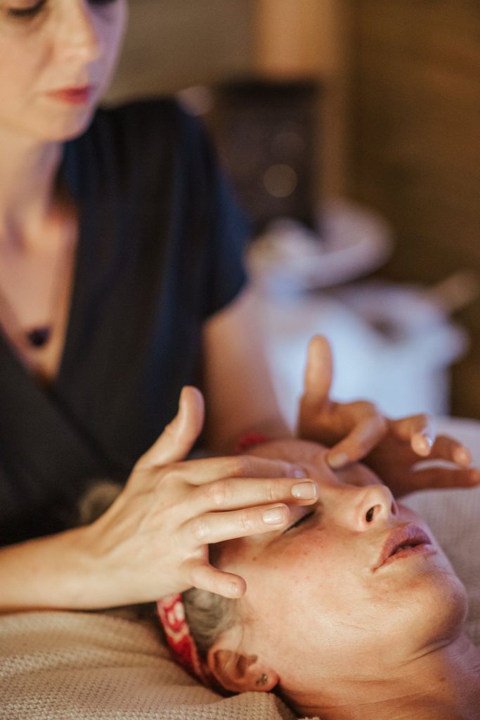 Mains réalisant un massage du visage